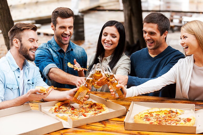 cheers-group-of-cheerful-young-people-eating-pizza-46XSSWV.jpg